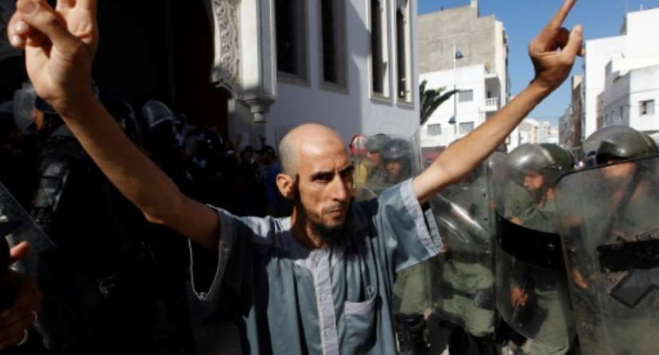 A demonstrator gestures in front of Moroccan security forces during a march in the northern Moroccan city of Al-Hoceima on July 20, 2017 in defiance of a government ban.  By STRINGER AFPFile