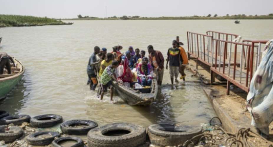 A dug-out canoe brings people across the Senegal river from Mauritania to Rosso.  By PATRICK MEINHARDT (AFP)