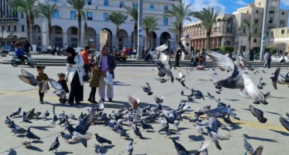 A family feeds pigeons in Libya's capital Tripoli on Tuesday, as politicians discussed the future structures of government in a bid to build peace in the long-troubled nation.  By Mahmud TURKIA AFP