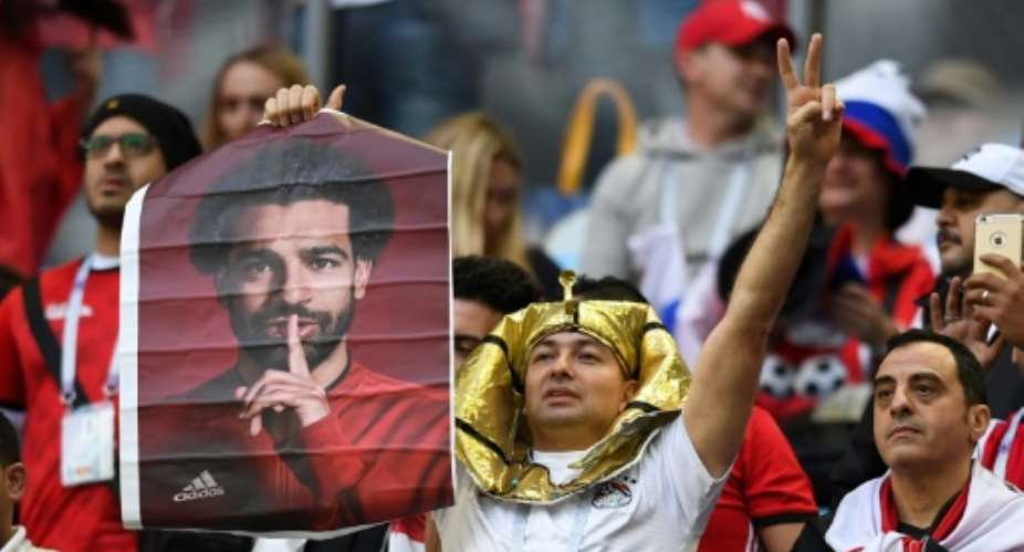 A fan holds a poster of Egypt forward Mohamed Salah ahead of a match against Russia at the World Cup on June 19, 2018.  By Olga MALTSEVA AFPFile