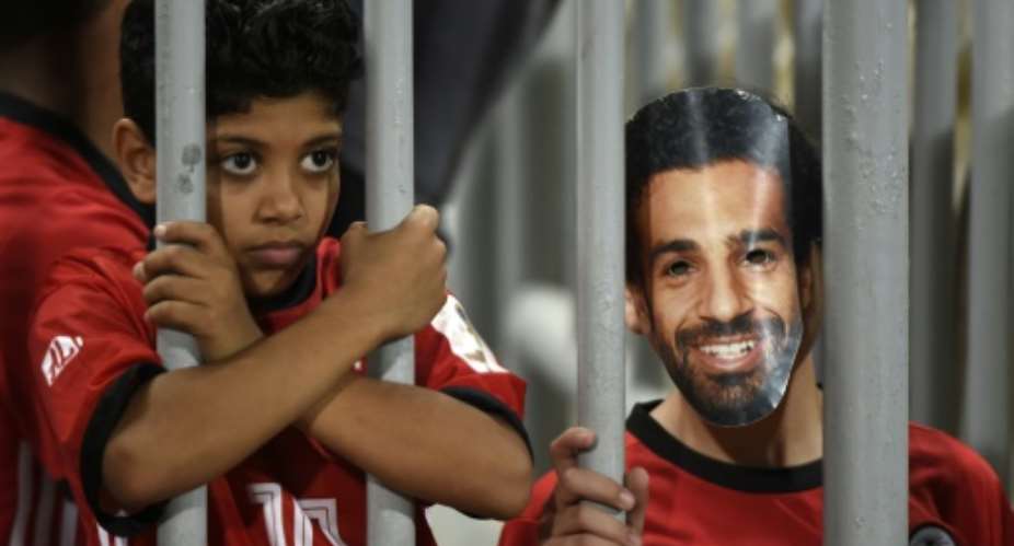 A fan wearing a mask of Egyptian football star Mohamed Salah poses for a photograph  prior to the 2019 Africa Cup of Nations qualifier between Egypt and Niger on September 8, 2018 at the Borg el-Arab stadium near the Mediterranean city of Alexandria.  By KHALED DESOUKI AFPFile