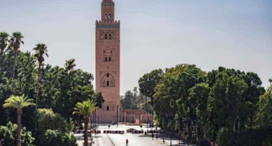 A few people walk by next to the Kutubiyya mosque's minaret tower at the Jemaa el-Fna square in the Moroccan city of Marrakesh on September 8, 2020, currently empty of its usual crowds due to the COVID-19 pandemic.  By FADEL SENNA AFP