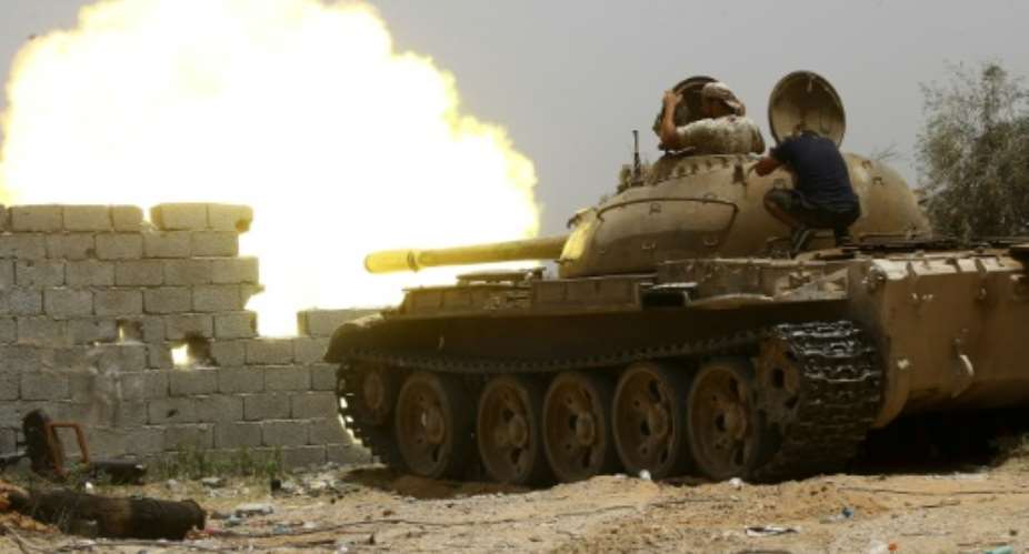 A file photo from June 2019 shows fighters loyal to the UN-recognised Government of National Accord GNA open tank fire south of the Libyan capital Tripoli during clashes with forces loyal to strongman Khalifa Haftar.  By Mahmud TURKIA AFPFile