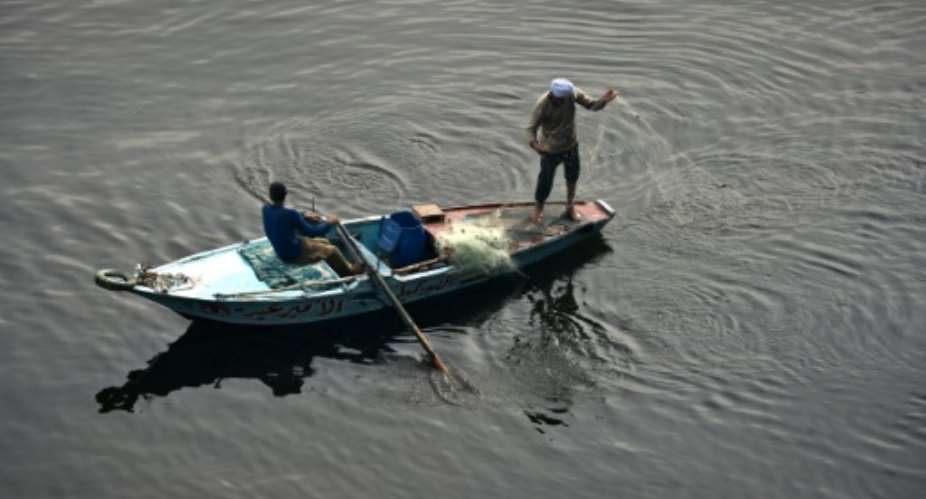 A file pictures shows an Egyptian fishermen throwing a net into the Nile river in Cairo on December 17, 2014.  By MOHAMED EL-SHAHED AFPFile