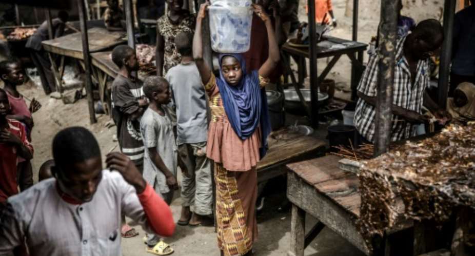 A girl selling water waits for costumers at a market, which was attacked last year by Boko Haram Islamists, in the Nigerian city of Mubi.  By Luis TATO AFP