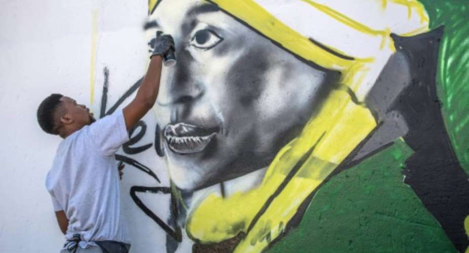 A graffiti artist painted a portrait of late South African anti-apartheid campaigner Winnie Mandela in Soweto earlier this month.  By MUJAHID SAFODIEN AFP