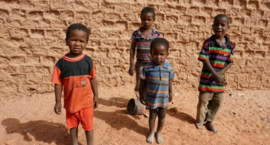 A group of children pose for photographs on a street in Agadez, northern Niger on April 1, 2017.  By ISSOUF SANOGO AFPFile