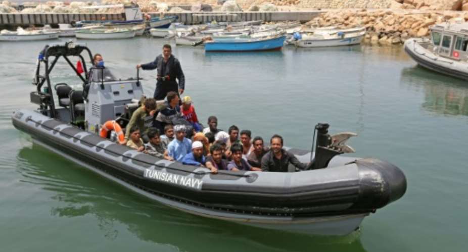 A group of migrants rescued by Tunisia's national guard during an attempted crossing of the Mediterranean by boat arrive at the port of el-Ketef in Ben Guerdane in southern Tunisia near the border with Libya.  By FATHI NASRI AFP