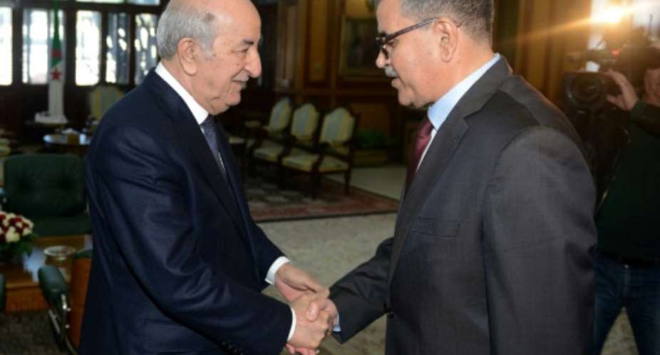 A handout picture released by the official Algeria Press Service APS shows Algerian President Abdelaziz Tebboune L receiving the newly appointed Prime Minister Abdelaziz Djerad in the capital Algiers on December 28, 2019.  By - APSAFPFile