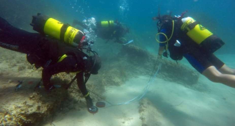A handout picture released by the Tunisian National Heritage Institute and the University of Sassari on August 31, 2017 shows archaeologists diving off the coast of Nabeul in northeastern Tunisia at the site of the ancient Roman city of Neapolis.  By Handout lInstitut national du patrimoine tunisien INP  University of SassariAFP