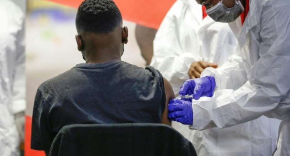 A healthworker administers the Sinovac Covid-19 vaccine to a teenager at the Sefako Makgatho Health Sciences University in Pretoria on Friday.  By Phill Magakoe AFP