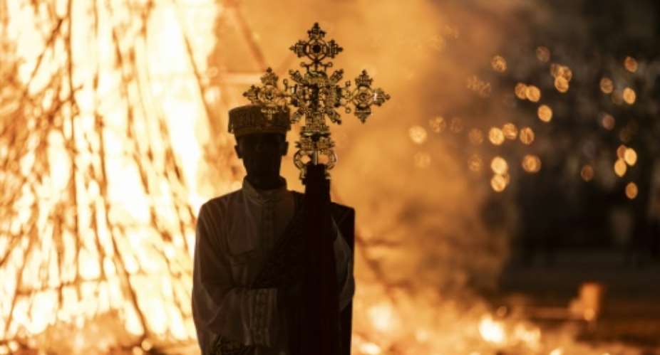 A high priest holds a cross while standing in front of a bonfire during the Meskel celebrations in Addis Ababa.  By Amanuel Sileshi AFP