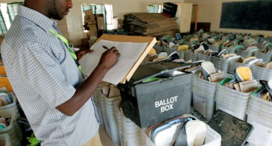 A Kenyan election official counts ballot boxes at a polling station in Wamba.  By Cyril Villemain AFP
