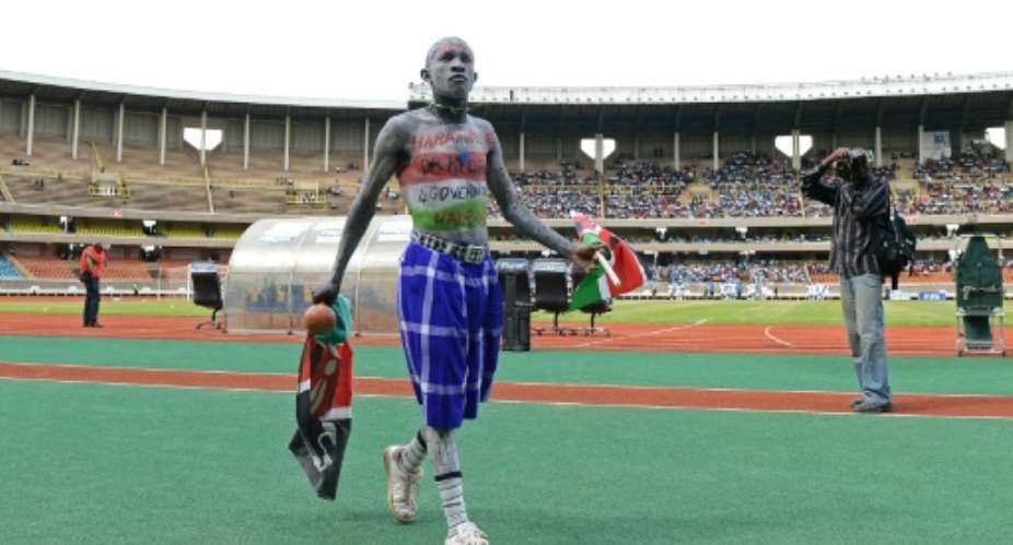 A Kenyan football fan walks on the pitch before an international match at Kasarani stadium in Nairobi.  By CARL DE SOUZA AFPFile
