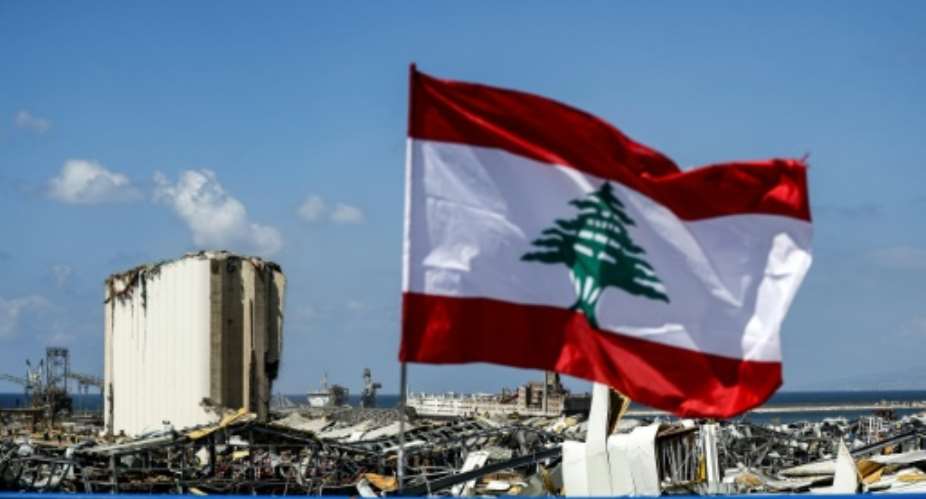 A Lebanese flag flies on a bridge near the port of Lebanon's capital Beirut, amid the destruction of Tuesday's explosion that killed over 150.  By JOSEPH EID AFP
