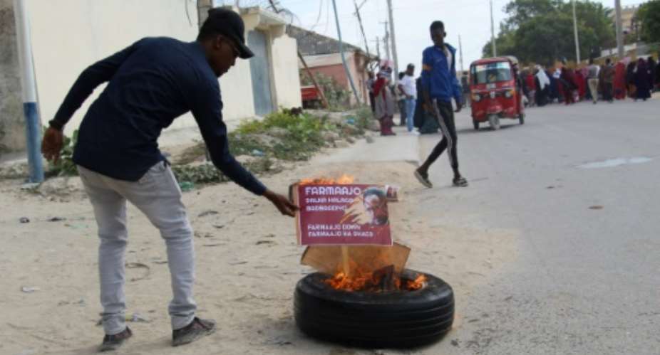 A man burns a poster of Somali President Mohamed Abdullahi Mohamed in Mogadishu in December 2020 amid a political impasse.  By STRINGER AFPFile