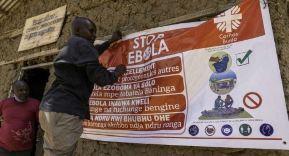A man hangs an Ebola awareness banner in the Kigonze displaced persons camp in Bunia, in the eastern DRC.  By Glody MURHABAZI (AFP)