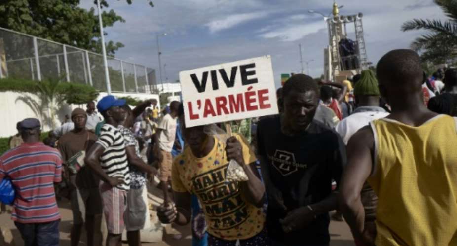A man holding a sign reading long live the army at a rally in Mali's capital Bamako in support of the junta.  By MICHELE CATTANI AFP