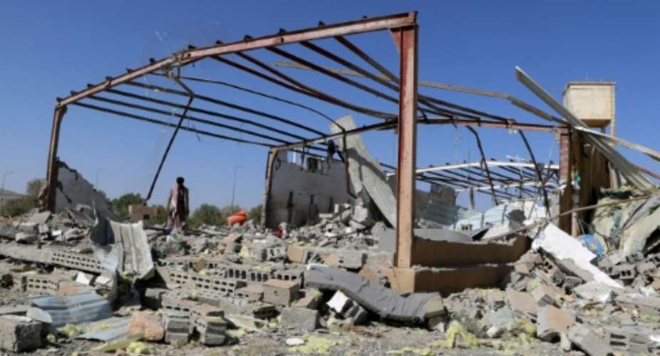 A man inspects the wreckage of a building destroyed in Yemen by a strike on a migrant centre attributed to the US.  By - (AFP)