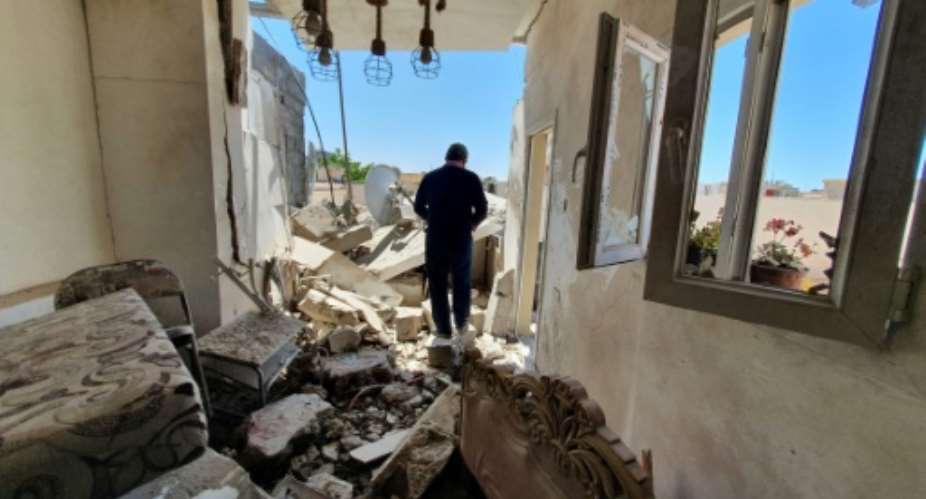 A man walks through the rubble of a building that was damaged when strongman Khalifa Haftar's forces shelled the neighborhood in the Libyan capital Tripoli on May 1, 2020 -- Hafter has been receiving help from Russian mercenaries, a UN report says.  By Mahmud TURKIA AFPFile