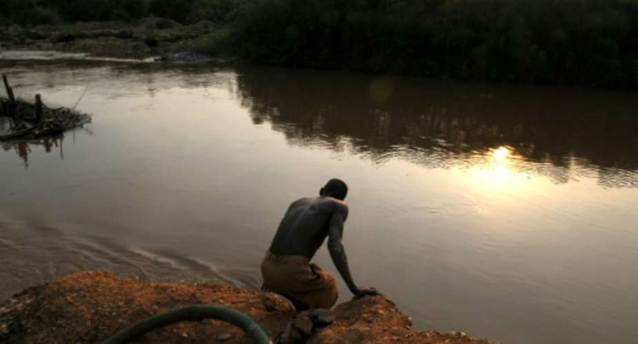 A man washes in a river after panning for gold in 2009.  By LIONEL HEALING AFPFile