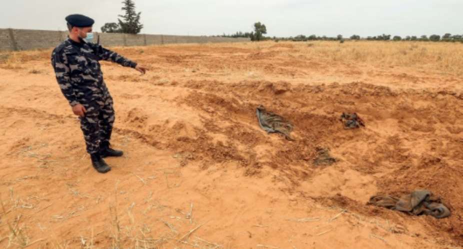 A member of security forces affiliated with the GNA's Interior Ministry surveyed the reported site of a mass grave in the town of Tarhuna, southeast of the capital Tripoli.  By Mahmud TURKIA AFP