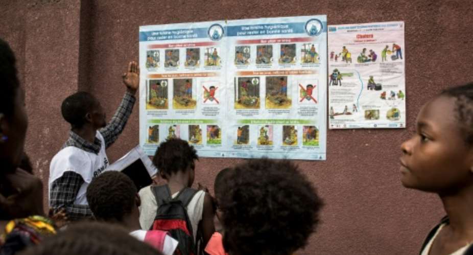 A member of the Congolese Red Cross explains the symptoms, risks and precautions of cholera to children in Kinshasa in January 2018, as the Democratic Republic of Congo experiences a cholera epidemic, with 125 registered deaths since February 2018.  By JOHN WESSELS AFPFile