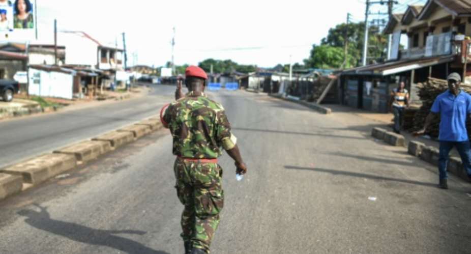 A military policeman walks the empty streets of Freetown.  By Saidu BAH AFP