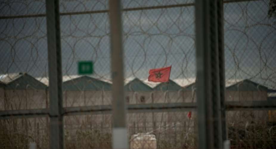 A Moroccan flag flies behind the border fence between Morocco and Spain's North African territory of Ceuta.  By Jorge Guerrero AFPFile