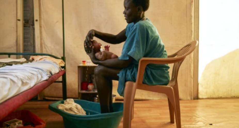 A mother washes her newborn infant at a hospital in a protected civilian site in Malakal, South Sudan. To encourage the peace process the Vatican is hosting a retreat for the warring rival leaders.  By ALEX MCBRIDE AFP
