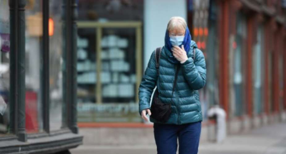 A New Yorker wears a face mask on the street.  By Angela Weiss AFP
