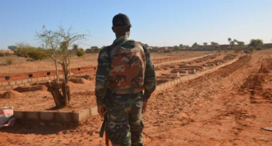 A Niger soldier looks at the graves of 71 Niger troops soldiers killed  in a jihadist attack on December 10, 2019, ahead of a regional summit to coordinate a response to the growing unrest..  By Boureima HAMA AFP