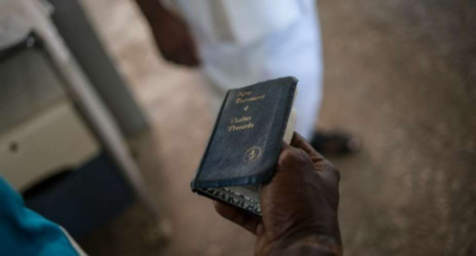 A Nigerian soldier holds a Bible in the substance abuse ward of the Federal Neuro Psychiatric Hospital in Maiduguri, northeastern Nigeria.  By Stefan Heunis AFP
