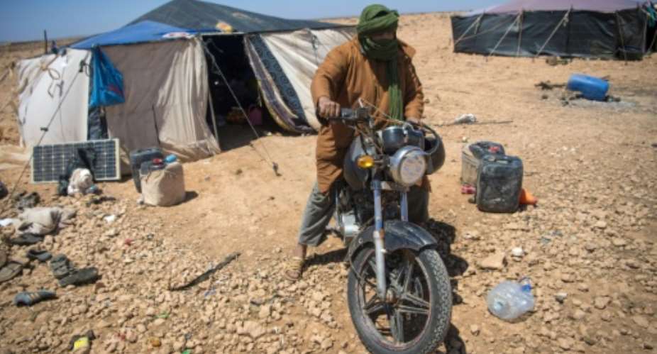 A Nomadic herder rides his motorcycle near tents in the southern Moroccan Tiznit province in the region of Souss-MassaDrought has turned parts of the plateaus of Tiznit arid, and when water becomes scarce, tensions rise.  By FADEL SENNA AFP
