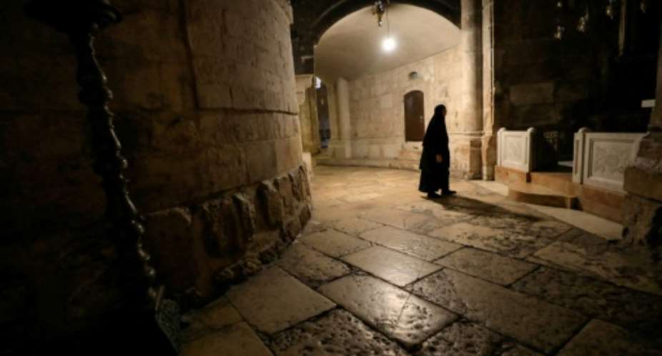 A nun walks along a deserted corridor in the Church of the Holy Sepulchre, believed by Christians to be the burial site of Jesus Christ.  By Emmanuel DUNAND AFP