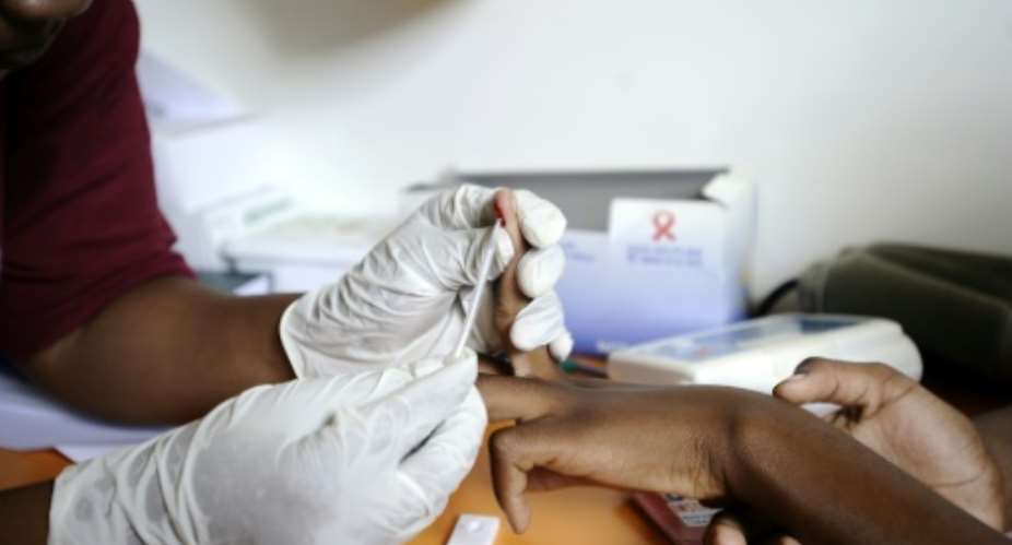 A nurse takes a blood sample on March 8, 2011 in a mobile clinic set up to test students for HIV at Madwaleni high school near Mtubatuba in Kwazulu Natal, South Africa.  By STEPHANE DE SAKUTIN AFPFile