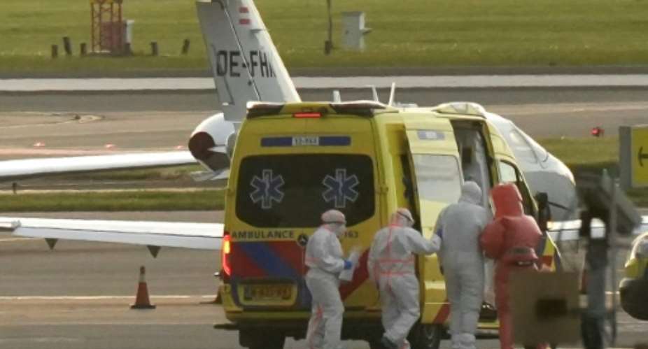 A person in a hazmat suit was escorted to an ambulance at Schiphol airport near Amsterdam on May 6, 2026.  By Lina Selg (AFP)