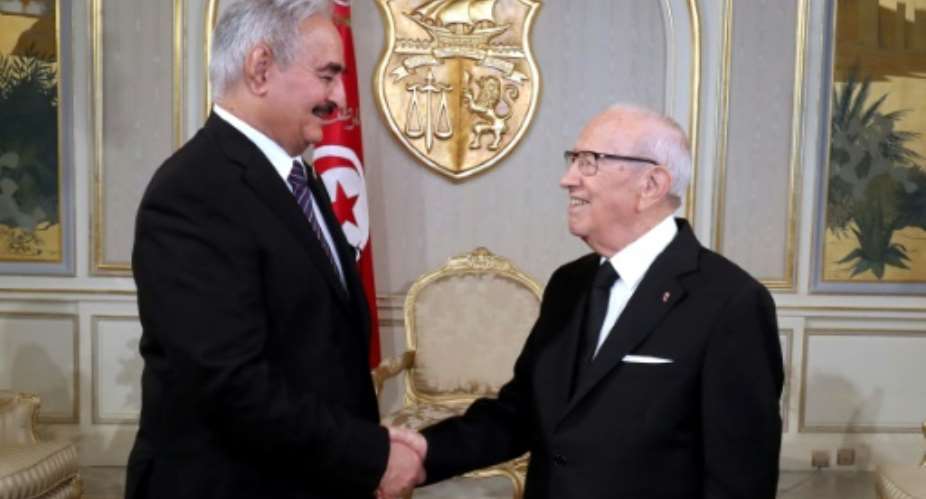 A photo released by the Tunisian Presidency Press Service shows Tunisian President Beji Caid Essebsi R meeting with Libyan General Khalifa Haftar on September 18, 2017 at Carthage Palace in Tunis.  By HO Tunisian PresidencyAFP
