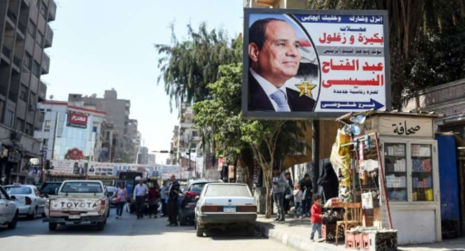 A picture taken on March 20, 2018 shows a large billboard showing a privately sponsored election advertisement supporting Egyptian President Abdel Fattah al-Sisi down a main street in the capital Cairo's northern suburb of Shubra.  By MOHAMED EL-SHAHED AFP