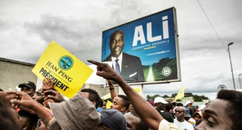 A poster of Gabonese President Ali Bongo Ondimba is seen as supporters of opposition candidate Jean Ping rally in Libreville on the last day of the presidential election campaign on August 26, 2016.  By Marco Longari AFPFile