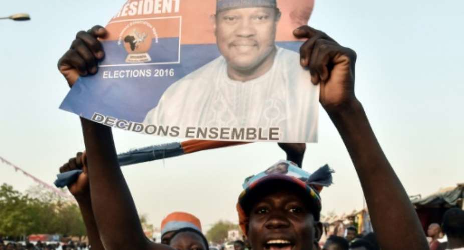 A protester holds up a flier of Niger opposition figure Hama Amadou, who turned himself in to police on Friday.  By ISSOUF SANOGO AFPFile