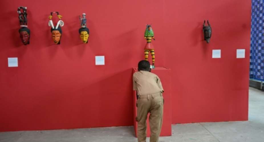 A school student looks at Zaouli masks on display in Ivory Coast as part of exhibits marking the return of German ethnologist Hans Himmelhebers collection of African ritual objects.  By Issouf SANOGO (AFP)