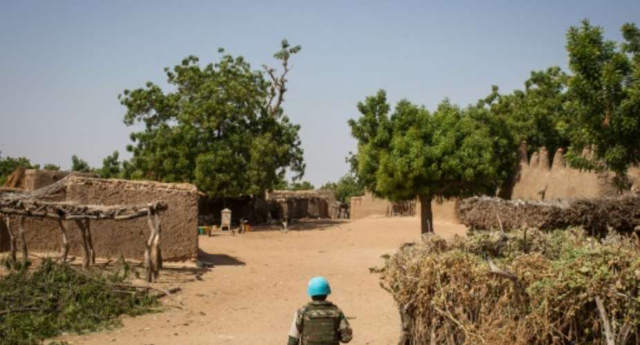 A Senegalese UN peacekeeper walks through the Malian village of Ogossagou where his commanders say there is a lull following two massacres.  By AMAURY HAUCHARD AFP