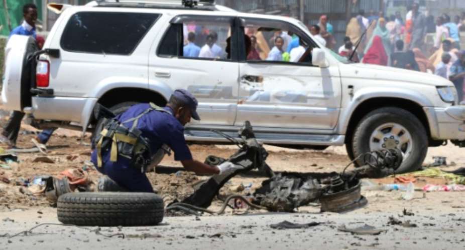 A Somali police officer investigates the scene of an October 1, 2018 suicide bomb attack in the capital Mogadishu claimed by Islamist jihadists Al-Shabaab.  By Abdirazak Hussein FARAH AFPFile