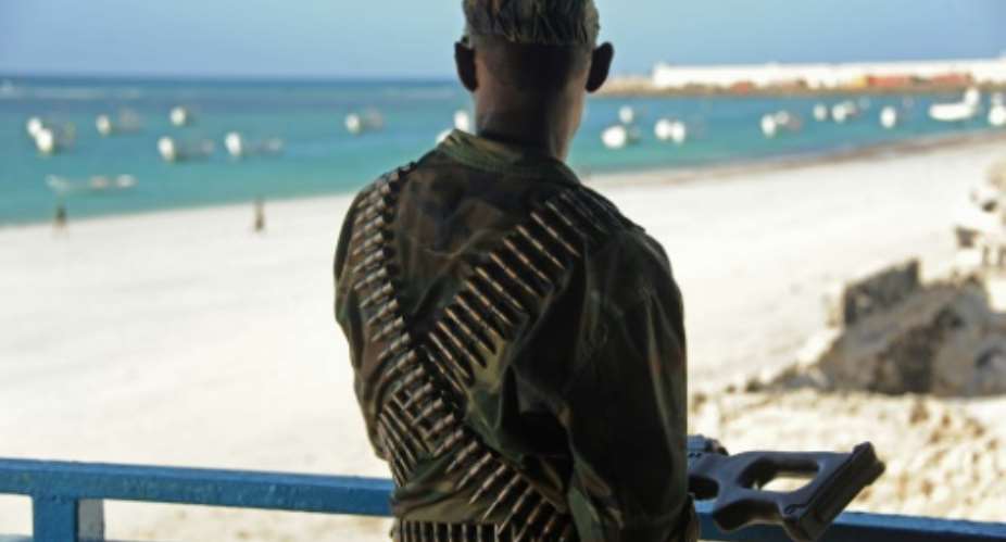 A Somali soldier looks at the Lido beach from the terrace of a restaurant on January 22, 2016.  By Mohamed Abdiwahab AFPFile