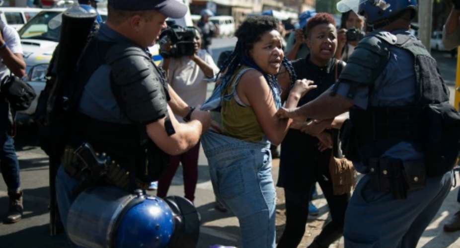 A student from the University of the Witwatersrand Wits is detained by South African police forces following clashes during a protest against the university fee increase on September 21, 2016 in Johannesburg.  By Mujahid Safodien AFPFile