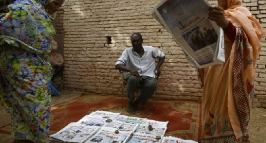 A Sudanese newspaper  vendor sits in a street on May 25, 2015.  By ASHRAF SHAZLY AFP