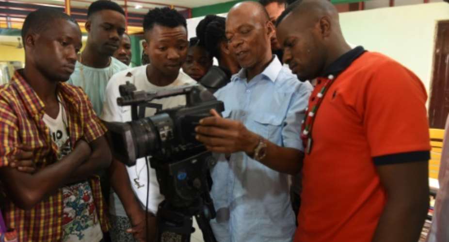 A teacher C at the PEFTI Film Institute teaches students to use a video camera, in Lagos.  By Pius Utomi Ekpei AFP