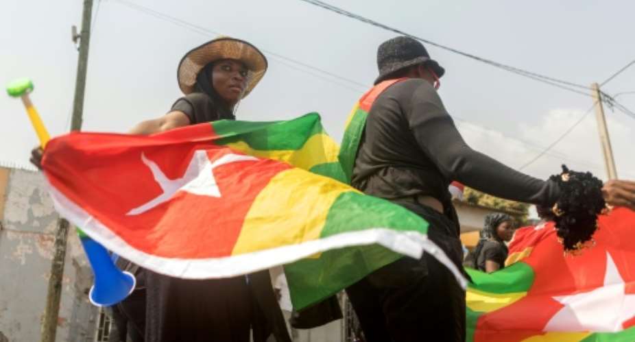 A Togolese woman dressed in black and holding the national flag in the capital Lome during a protest rally against Togo's president in 2018.  By Yanick Folly AFPFile