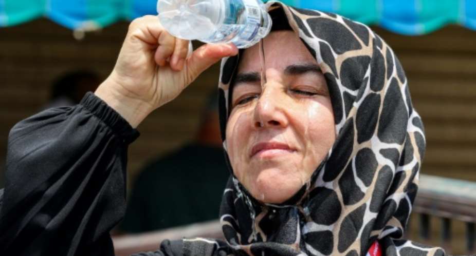 A Turkish pilgrim pours cold water on her head to cool off in Saudi Arabias holy city of Mecca.  By Abdel Ghani BASHIR (AFP)
